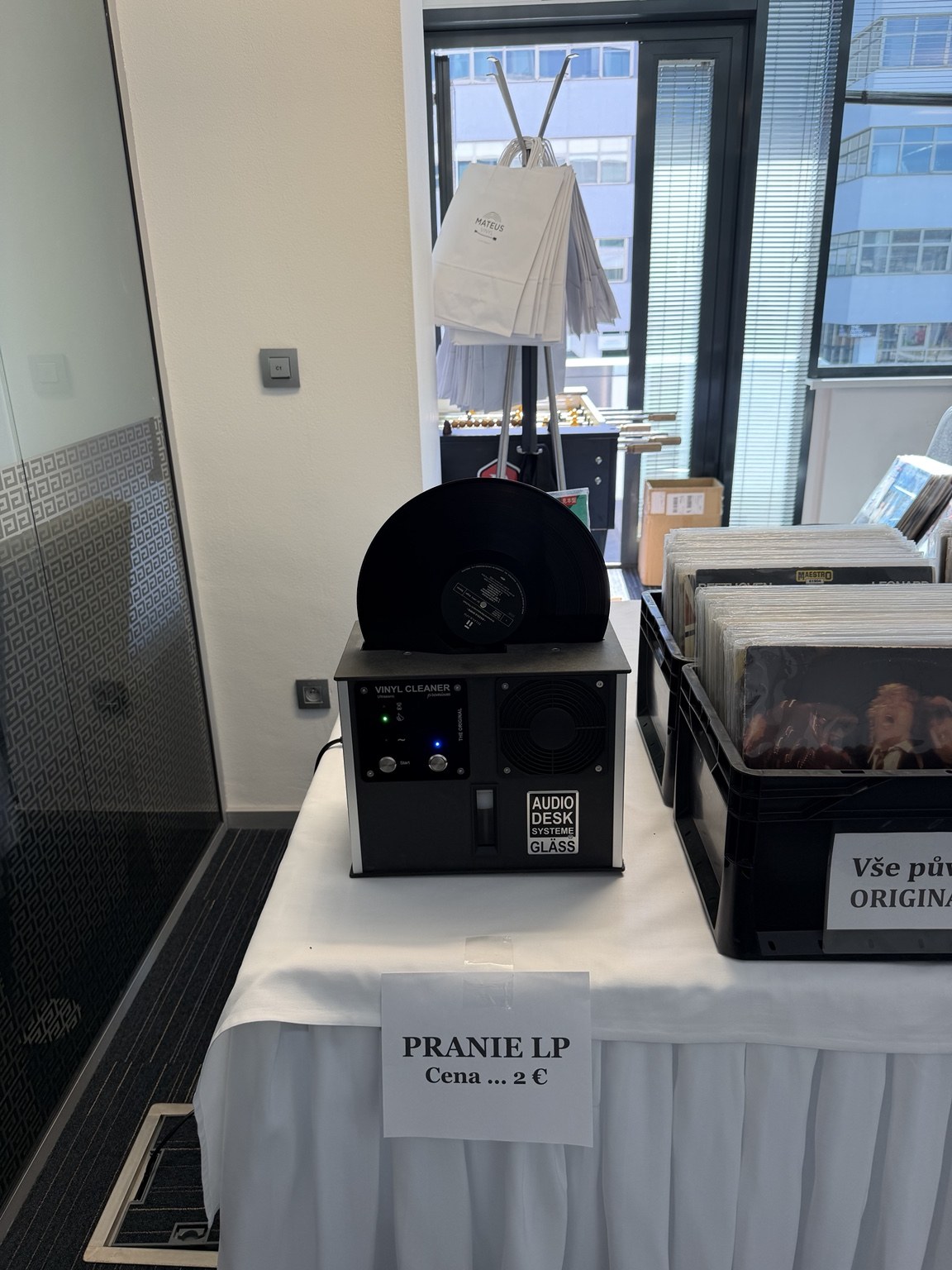 Pračka gramofonových desek vedle nabídky vinylů u stánku MATEUS VINYL